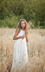 Teen girl in wheat field in a summer day