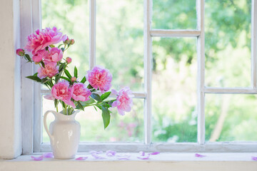 pink peony in vase on grunge white interior