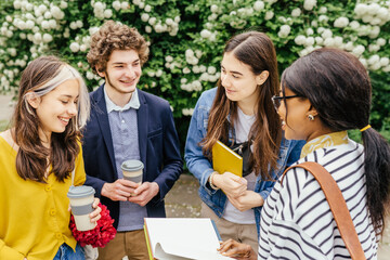Education, campus, friendship and people concept. Group of happy multi ethnic students talking, standing in circle meeting outdoor in park.