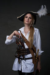 Fototapeta premium Elegant woman corsair posing with pistols indoors studio