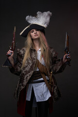Attractive woman pirate with guns against dark background
