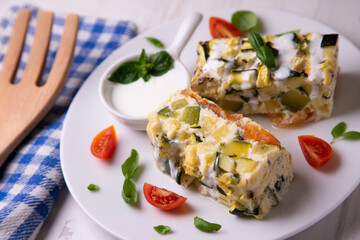 Zucchini pie with egg and yogurt sauce.