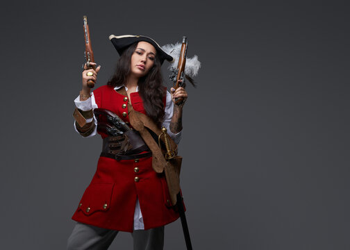 Brunette corsair with guns dressed in pirate outfit