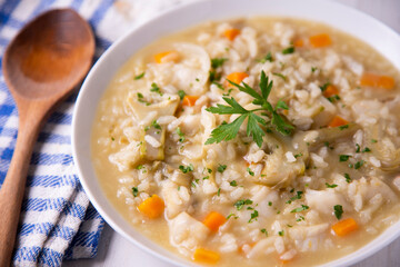 Soupy rice with cod, carrot and artichokes. Traditional Spanish tapa.