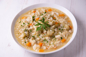 Soupy rice with cod, carrot and artichokes. Traditional Spanish tapa.