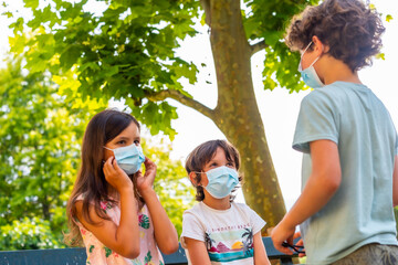Children taking off their masks at the end of the coronavirus pandemic. End of restrictions abroad, happy to be able to breathe well, covid19
