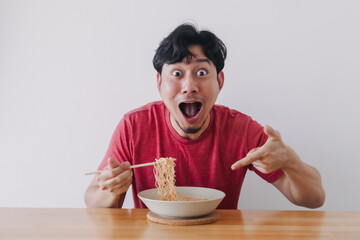 Wow and surprised funny face of Asian man eat instant noodle.