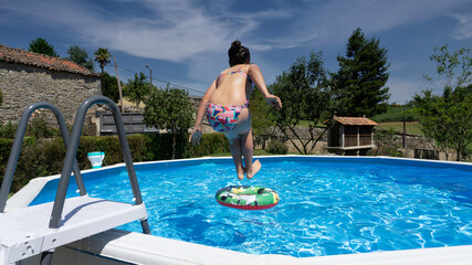 girl jumping into the pool