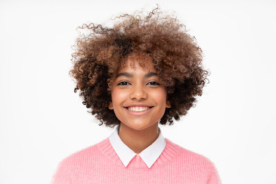 Portrait of smiling african american teen girl with curly afro hair, isolated on gray background
