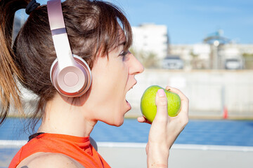 young woman biting green apple, healthy lifestyle concept, healthy teeth