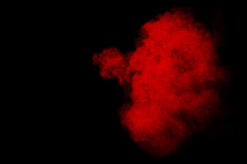 Red powder explosion cloud on black background.
