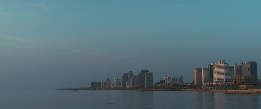 A beautiful cityscape of Tel Aviv and the Mediterranean sea at dusk. Slow motion, long shot. 