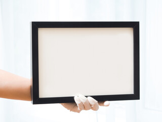 A woman wearing medical gloves holds an empty frame. Here can be your text