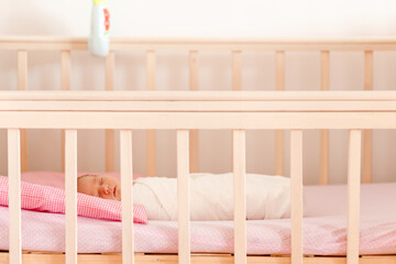 Fototapeta na wymiar Newborn baby lies in a crib