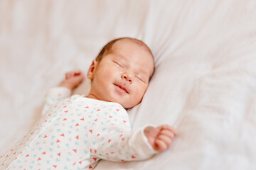 Newborn baby sleeps sweetly on white plaid. Newborn photo shoot