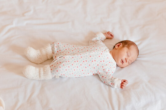 Newborn baby sleeps sweetly on white plaid. Newborn photo shoot