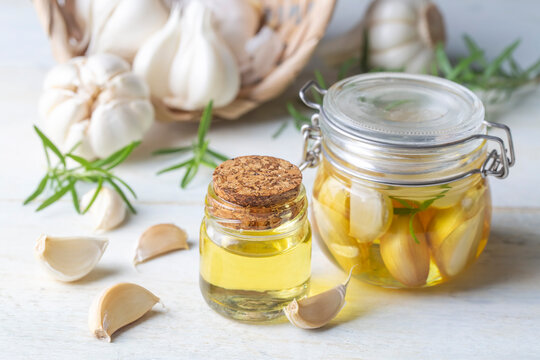 Fresh garlic and garlic oil on the wooden background