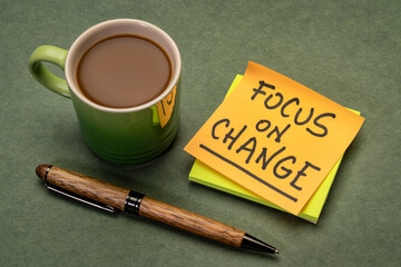 focus on change inspirational advice or reminder - handwriting on a sticky note with a cup of coffee, lifestyle and personal development concept