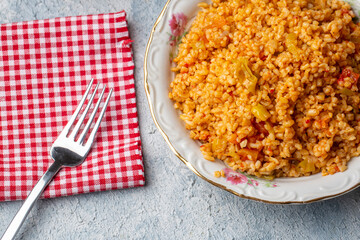 Traditional turkish bulgur pilaf with tomato sause in plate (Turkish name; meyhane pilavi)