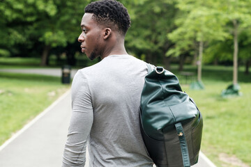 Fit young black man going to training with gym bag.