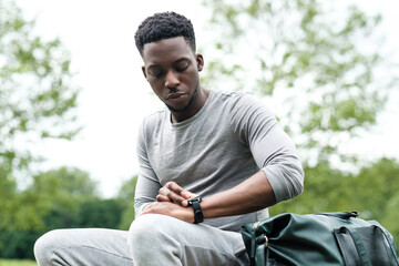 Portrait of black male sit on a table on a fitness outfit.