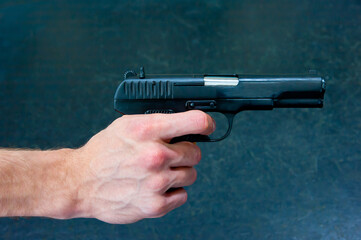 A man's hand holds a TT pistol.