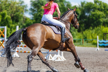 Young teen rider girl on show jumping competition