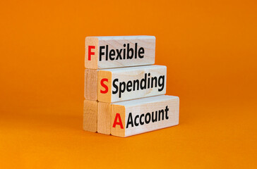 FSA flexible spending account symbol. Concept words FSA flexible spending account on wooden blocks on a beautiful orange background. Business and FSA flexible spending account concept.