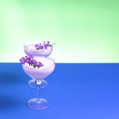 A gin cocktail with egg white foam garnished with blue flowers