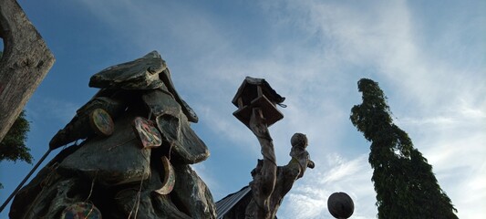 bird house on old wooden tree on cloudy blue sky