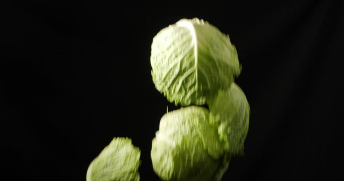 Green Chinese cabbage on a black background. It flies up and falls down