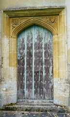 Fototapeta na wymiar wooden doorway to the restored (1889) saxon church of a small village in Wiltshire