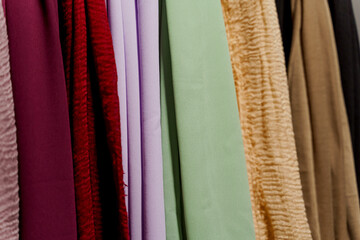 Silk scarf muslim. Multi-colored plain scarves on hanger.