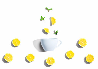 Fresh yellow lemons with tea cup overhead view