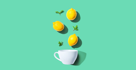 Fresh yellow lemons with tea cup overhead view