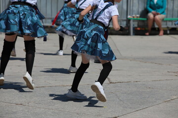 Children play sports and fitness outside.A group of girls jumps at a class in the schoolyard.Image of the physical development of students