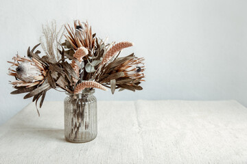 Arrangement of dried flowers in a glass vase copy space.