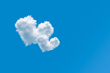 Couple of heart shaped clouds on a clear blue sky background. Concept of love and romance. Pair of cloud hearts in sky. Valentine's day design element. Greeting card with copy space. Love symbol.