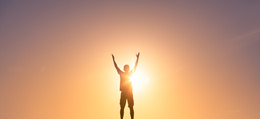 Young man lifting hands up to the sky feeling happy and free. 