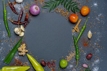 Circular pattern of Chillies, Garlic, Ginger, Salt, Mustard, Curry leaves, Onion, Tomatoes, Capsicum, Fenugreek, Dried chillies and Cinnamon.