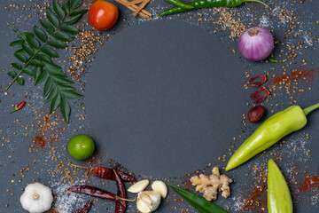 Circular pattern of Chillies, Garlic, Ginger, Salt, Mustard, Curry leaves, Onion, Tomatoes, Capsicum, Fenugreek, Dried chillies and Cinnamon.