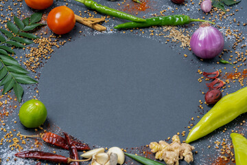 An aroma of basic necessities such as Chillies, Garlic, Ginger, Salt, Mustard, Curry leaves, Onions, Tomatoes, Capsicums, Fenugreek, Dried chillies and Cinnamon displayed in a circular pattern.