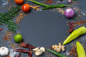 An aroma of basic necessities such as Chillies, Garlic, Ginger, Salt, Mustard, Curry leaves, Onions, Tomatoes, Capsicums, Fenugreek, Dried chillies and Cinnamon displayed in a circular pattern.