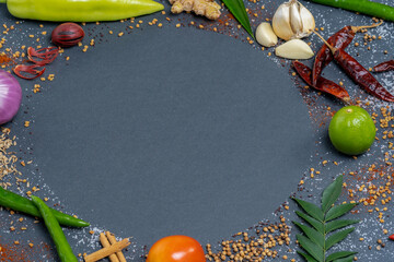 Circular pattern of Chillies, Garlic, Ginger, Salt, Mustard, Curry leaves, Onion, Tomatoes, Capsicum, Fenugreek, Dried chillies and Cinnamon.
