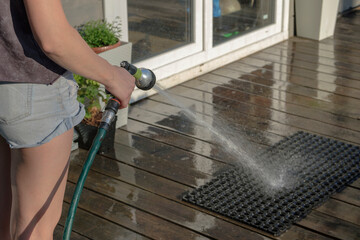 the girl washes the rubber mat on the terrace