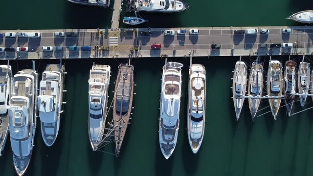 Luxury Yachts And Sailboats Docked At The Marina With Parked Cars In Palma De Mallorca, Spain. aerial top-down