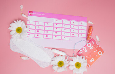 Menstruation calendar with cotton tampons , sanitary pads, white flower . Woman critical days, woman hygiene protection