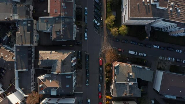 Aerial birds eye overhead top down view of calm morning in streets of Bornheim neighbourhood. Cars parked on side of road in front of buildings. Vertical panning. Frankfurt am Main, Germany