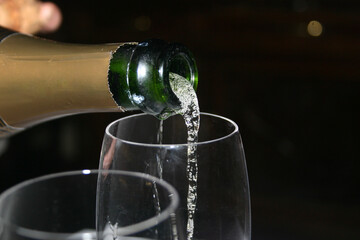 bartender pouring champagne into glass, closeup