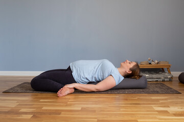 Fototapeta na wymiar Reclining Hero Pose or Supta Virasana. Pregnant woman resting in yoga asana